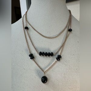 Triple goldtone chain necklace with black faceted beads